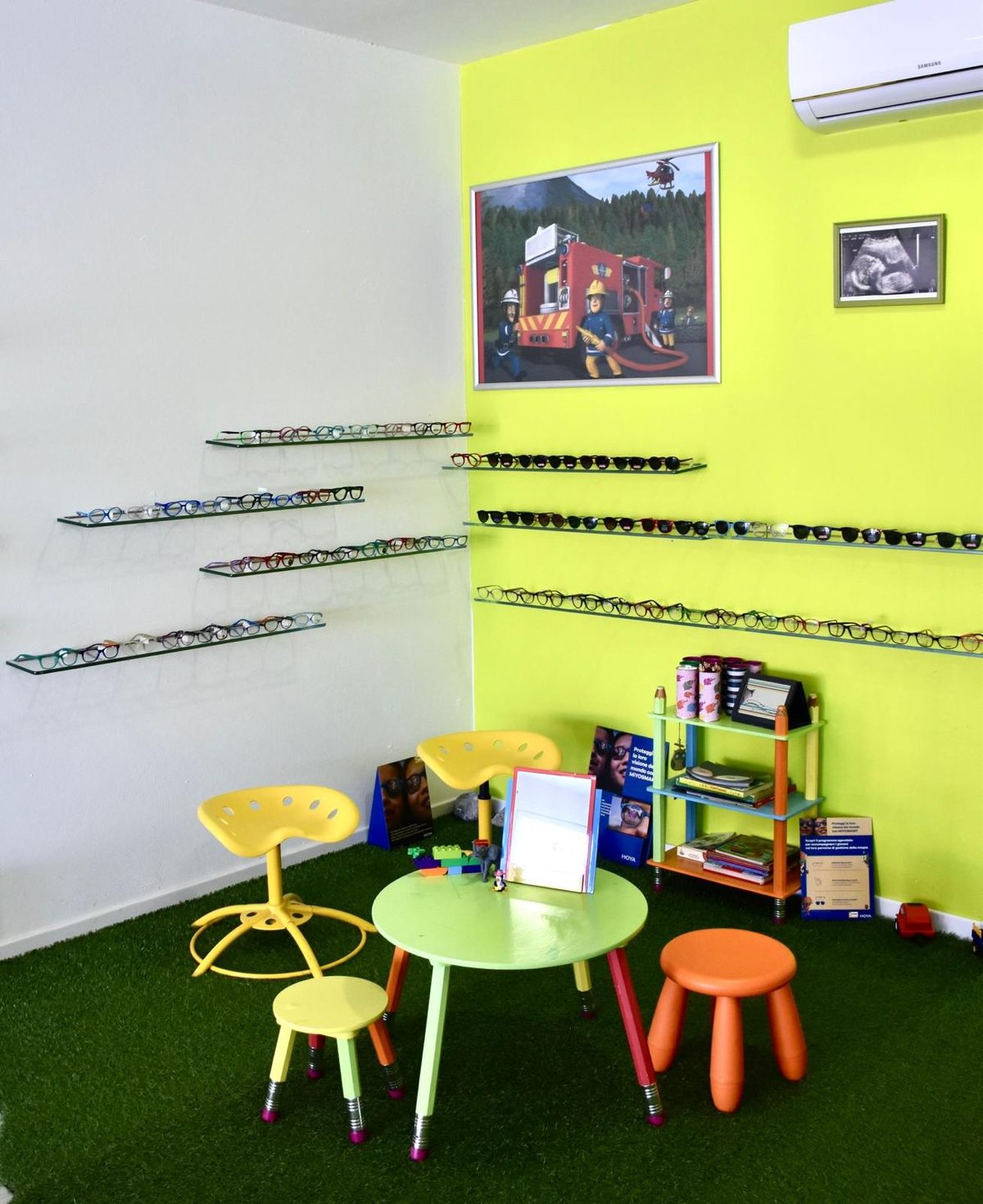 Reparto bambini di Optik Center con prato sintetico e lenti Hoya MiYOSMART per il controllo della miopia